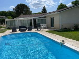 a large blue swimming pool next to a house at Villa entre bordeaux et saint emilion in Cursan