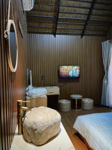 a bedroom with a bed and a large rock chair at Lá Garden Homestay in Long Xuyên