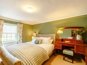 een slaapkamer met een bed en een bureau met een spiegel bij 3 bed property in Swinton 89133 in Swinton