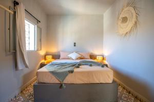 a bedroom with a bed with two lamps on it at Piccolo Bike Hotel in Lalla Takerkoust