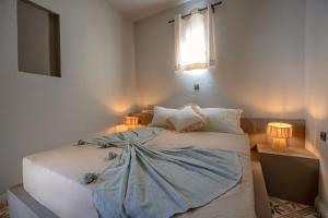 a bedroom with a bed with a blanket on it at Piccolo Bike Hotel in Lalla Takerkoust
