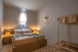 a bedroom with a bed with two lamps and a fan at Piccolo Bike Hotel in Lalla Takerkoust
