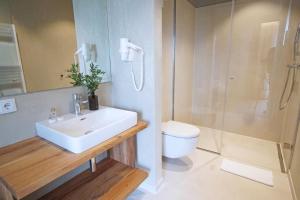 a bathroom with a sink and a toilet and a shower at Mahorko Wein Wellness Wasserbüffel in Glanz an der Weinstraße