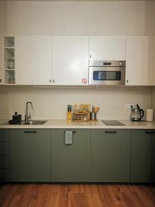 a kitchen with white cabinets and a sink at Atlas Apartment in the historical center of Košice with free private parking in Košice