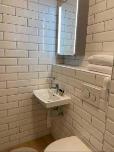 a white bathroom with a sink and a toilet at Studio très pratique ! in Le Mont-sur-Lausanne