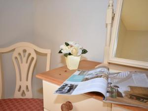 einen Tisch mit einer Vase Blumen und einem Buch in der Unterkunft 1 Bed in Appledore CAPTV in Appledore