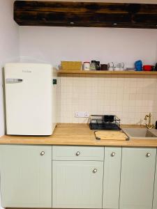 eine Küche mit einem weißen Kühlschrank und einer Spüle in der Unterkunft Cottage Studio in Borzęcin Duży
