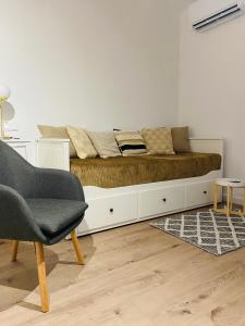 Bett in einem Zimmer mit Sofa und Stuhl in der Unterkunft Cottage Studio in Borzęcin Duży