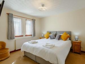 una camera da letto con un grande letto bianco con cuscini gialli di 2 bed property in Nairn The Highlands 89176 a Nairn