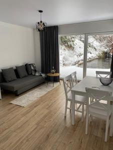 ein Wohnzimmer mit einem Sofa und einem Tisch in der Unterkunft Котедж in Mischhirja