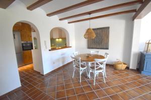 una cucina e una sala da pranzo con tavolo e sedie di Casa Rosa Javea a Jávea