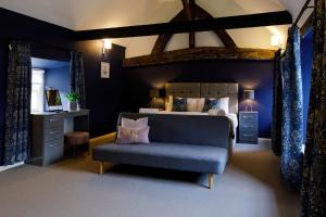 a bedroom with a bed and a blue couch at Canon Gate in Chichester