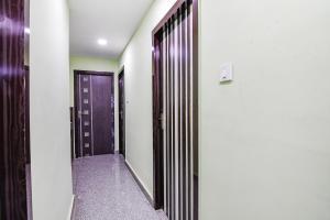 a hallway with a purple door and a hallway with at FabExpress Laxmi Inn in kolkata