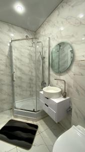 a white bathroom with a sink and a shower at Евродвушка в ЖК Каратал in Kostanay