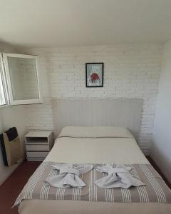 1 dormitorio con 1 cama con 2 toallas en El mirador de estrellas en Santa Rosa de Calamuchita