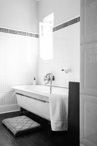 y baño con bañera y lavamanos. en Portland Manor en Rheenendal