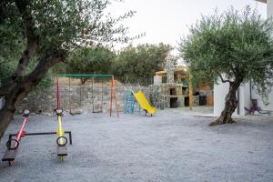 a playground with two swings and a swing at Villa Nontas Ntina with Private Pool & Playground in Rethymno Town
