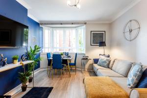 ein Wohnzimmer mit einem Sofa und einem Tisch in der Unterkunft West Kensington balcony flat beside Queens club in London