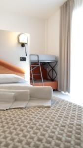 a hotel room with a bed and a table at Hotel Nobel in Rimini
