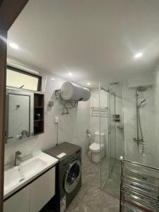 uma casa de banho com uma máquina de lavar roupa num lavatório e um chuveiro em Studio Apartment in Kigali em Kigali