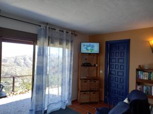 uma sala de estar com uma porta de vidro deslizante e uma janela em Vine Ridge Studio and Apartment em Comares