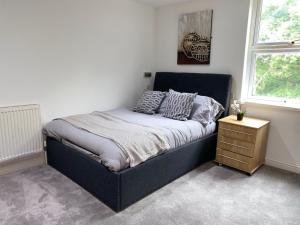 1 cama con cabecero azul en un dormitorio en Sapphire Suites, en Reading