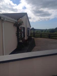 a white house with a fence and a patio at Atlantic House in Lisdoonvarna