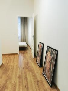 a room with three framed paintings on a wall at Atlas Apartment in the historical center of Košice with free private parking in Košice