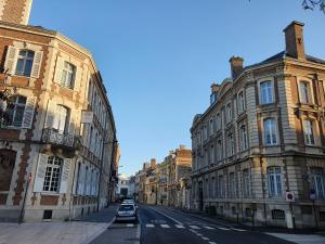 a city street with buildings and cars parked on the street at Hôtel Spa Marotte in Amiens