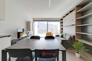 una cucina e un soggiorno con un grande tavolo e sedie di Favoloso e Moderno a Bellinzona -By EasyLife Swiss a Bellinzona
