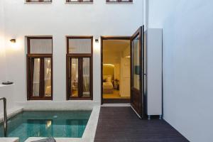 Le Bijou Luxury Suites Rethymno في مدينة ريثيمنو: منزل به مسبح بجانب مبنى