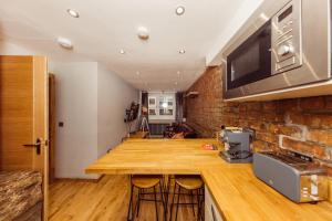 cocina con encimera de madera y pared de ladrillo en Superb Luxury Quality Central Apartment on Canal, en Edimburgo