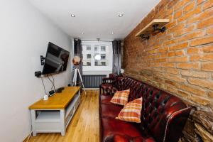 ein Wohnzimmer mit Sofa und Ziegelwand in der Unterkunft Superb Luxury Quality Central Apartment on Canal in Edinburgh