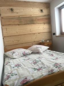Bett mit einem Kopfteil aus Holz und 2 Kissen in der Unterkunft Pokoje u Tosi i Czesia in Gliczarów Górny