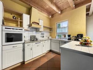 cocina grande con armarios blancos y encimera en Weber-Grill # Kamin # Indoorschaukel # Bose-Anlage en Wernigerode
