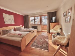 ein Schlafzimmer mit einem Bett und einer roten Wand in der Unterkunft Haus Wallis - Ski-In Ski-Out mit Frühstück am Arlberg in Warth am Arlberg