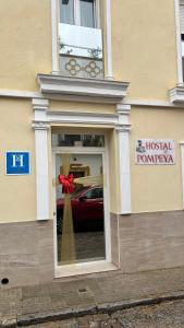 un edificio con una finestra con un'auto rossa di Hostal Pompeya Merida a Mérida
