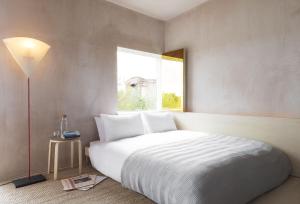 een slaapkamer met een wit bed en een raam bij Channel View, Dungeness by Bloom Stays in Dungeness