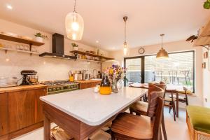 a kitchen with a table and some chairs in it at Coastal Gem With Hot Tub in Kent