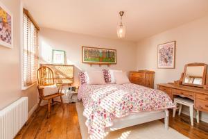 a bedroom with a bed and a desk and a chair at Coastal Gem With Hot Tub in Kent