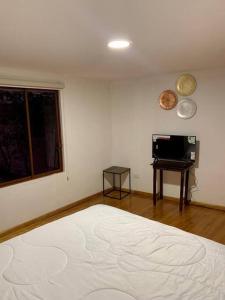 a room with a bed and a window and a table at Suite Eugenia ubicada en el centro de Estreno in Cuenca