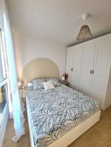 een slaapkamer met een groot bed en een blauwe deken bij Moderne et charmant T2 in Villiers-le-Bel
