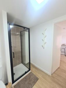ヴィリエ・ル・ベルにあるModerne et charmant T2のバスルーム(ガラスドア、シャワー付)