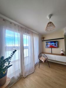 ein Wohnzimmer mit einem großen Fenster mit weißen Vorhängen in der Unterkunft Moderne et charmant T2 in Villiers-le-Bel