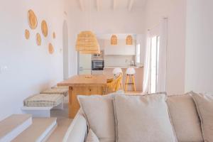 a living room with a couch and a table at Son Bou Sunset Villas By MENORCARENTALS in Son Bou