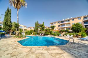 uma piscina num resort com uma palmeira em Paradise Gardens 1 C-003 em Pafos