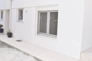 een wit gebouw met een raam aan de zijkant bij Traveller's Nest Studio close to center,port,airport in Heraklion