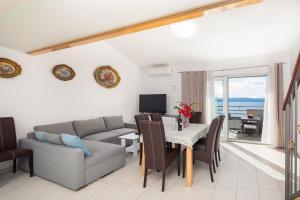 a living room with a couch and a table with chairs at Prestige Apartments in Jesenice