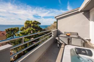 a balcony with a tub and a view of the ocean at Prestige Apartments in Jesenice +66 photos