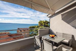 a balcony with a table and chairs and a view of the ocean at Prestige Apartments in Jesenice +42 photos